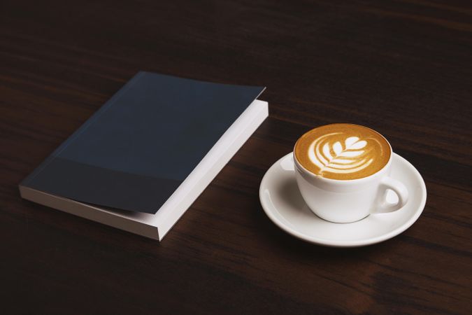 Cappuccino and navy notebook on wooden table