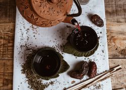 Aromatic tea dates and clay teapot on table