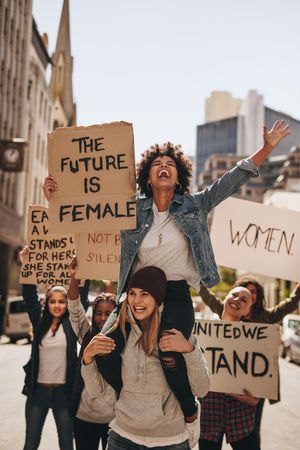 Group of protesters enjoying during a women's march with signboards