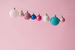 Colorful pastel Christmas decoration balls on pink background