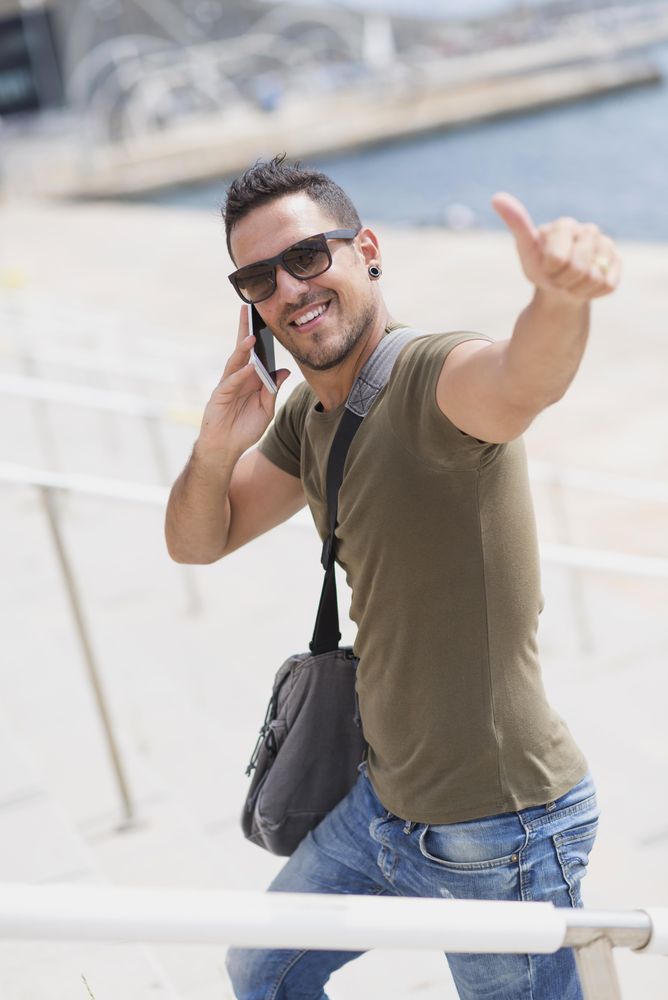 Male making thumbs up gesture while talking on cellphone