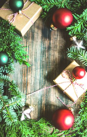 Christmas present boxes on wooden table with green and red bauble ornaments