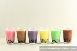 Row of colorful boba teas in studio space be2zA0