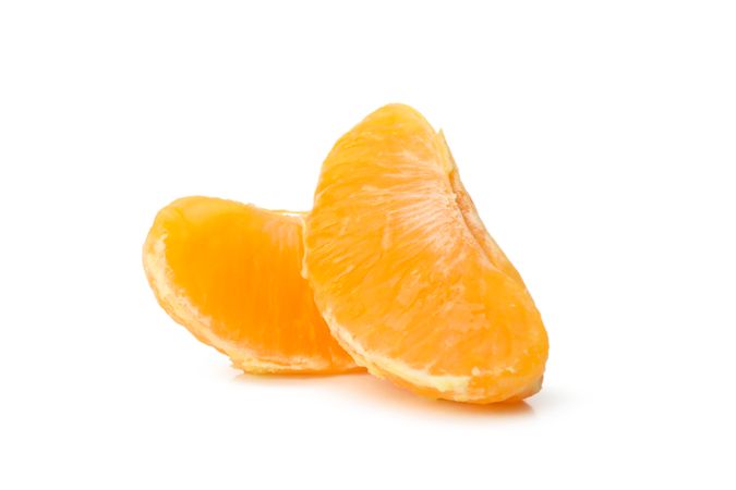 Pieces of ripe mandarin isolated on light background