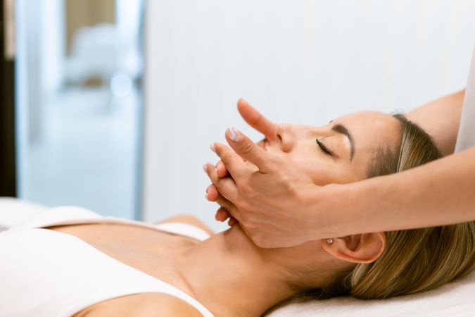 Side view of woman having relaxing face massage