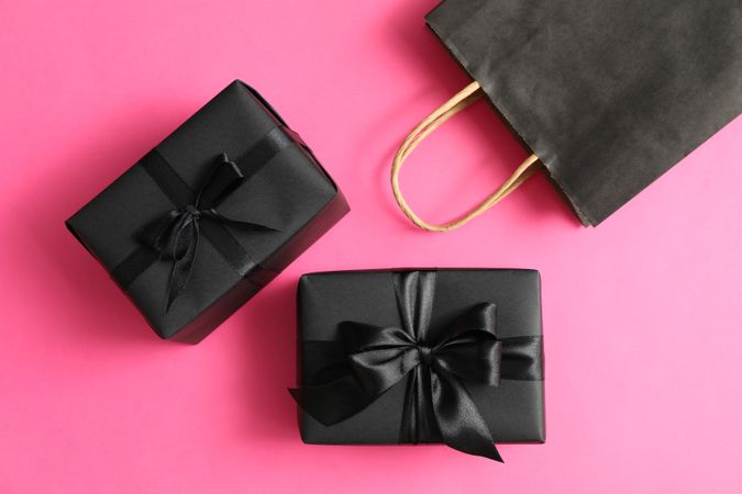 Paper bag and gift boxes on pink background