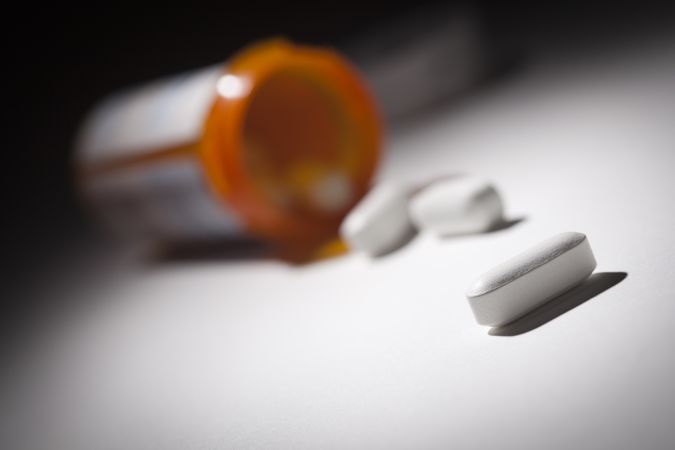 Medicine Bottle and Pills Under Spot Light