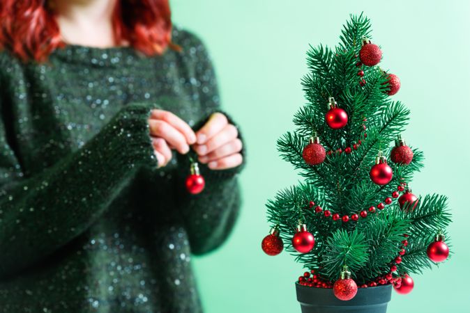 Decorated Christmas tree and girl holding in hands Christmas bauble in the background