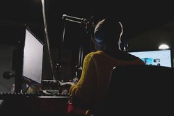 Unrecognizable woman operating sound mixer in recording studio