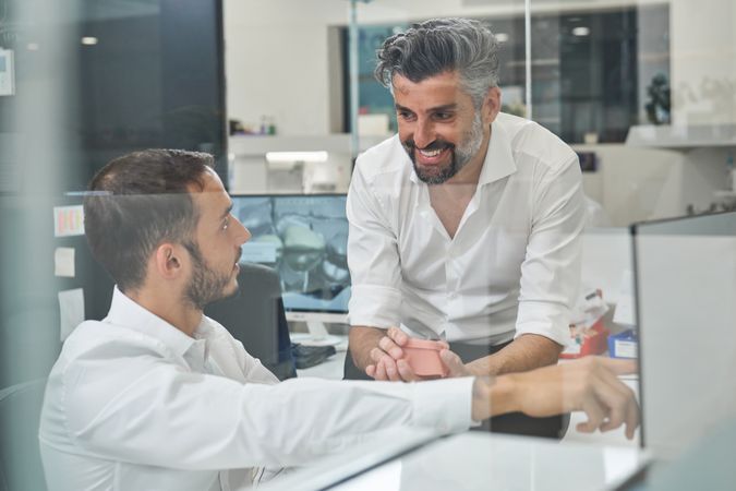 Joyful men discussing project in office