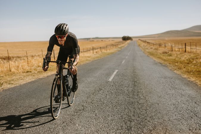 Bicycle rider riding bike on asphalt road