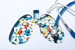 Close up of lung shape cut out of paper with pills underneath with doctor’s stethoscope