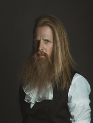Confident adult red haired medieval magnate looking at camera