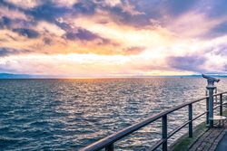 Binoculars on a lake shore at sunset