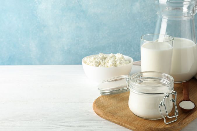 Fresh dairy products on plain wooden table, copy space