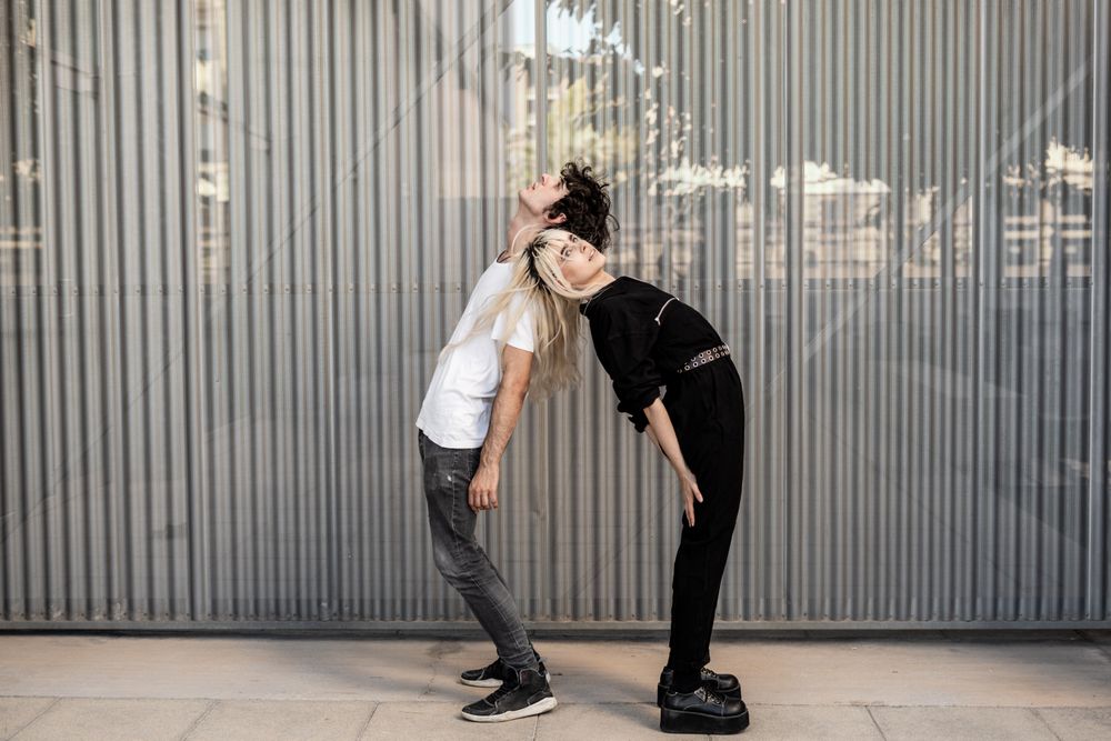 Loving man and woman supporting each other while standing back to back