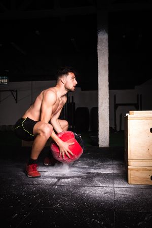 Man throwing ball on wall in gym