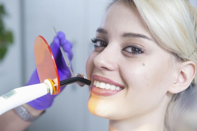 Woman smiling while having a dental procedure done
