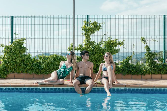 Friends playing with water pistols in the pool