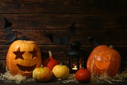 Halloween pumpkins and candles on dark wooden background, copy space
