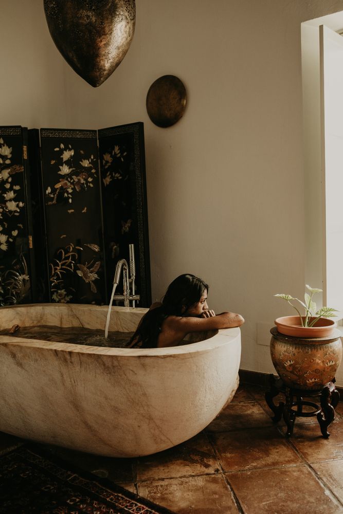 Melancholic Woman sitting and washing in bath