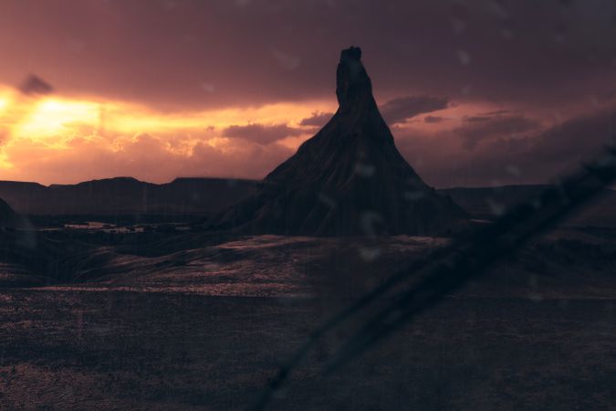 Stone peak in desert against evening sky