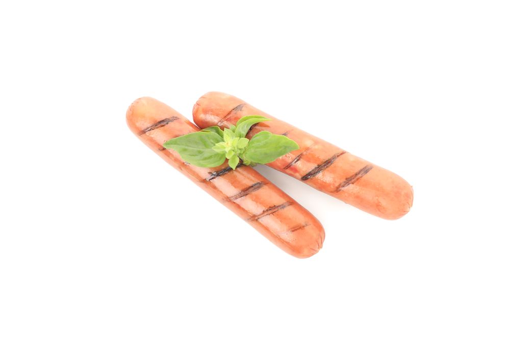 Two sausages with grill marks and garnish