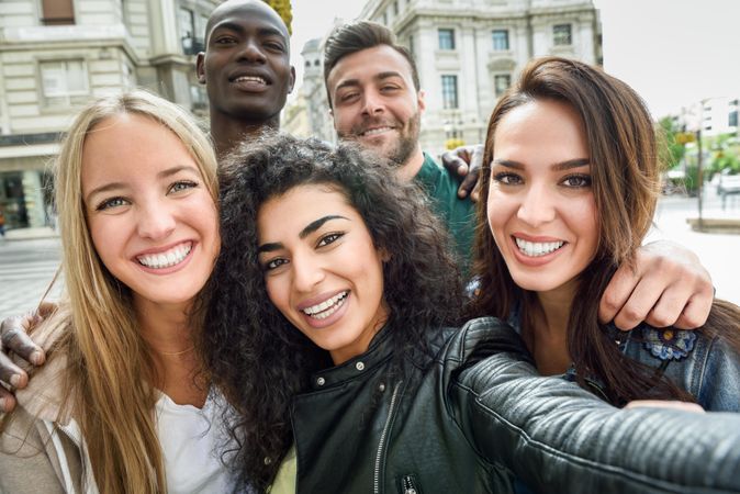 Group of friends smiling at camera taking selfie