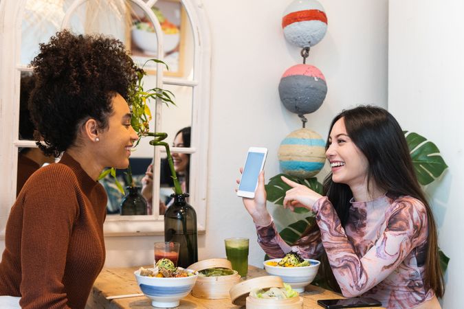 Smiling multiethnic women eating in restaurant