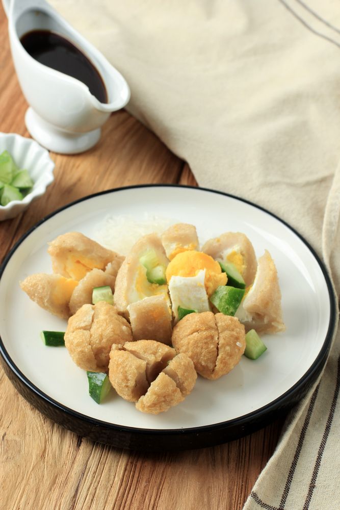 Cut up fish cake on plate with side sauce