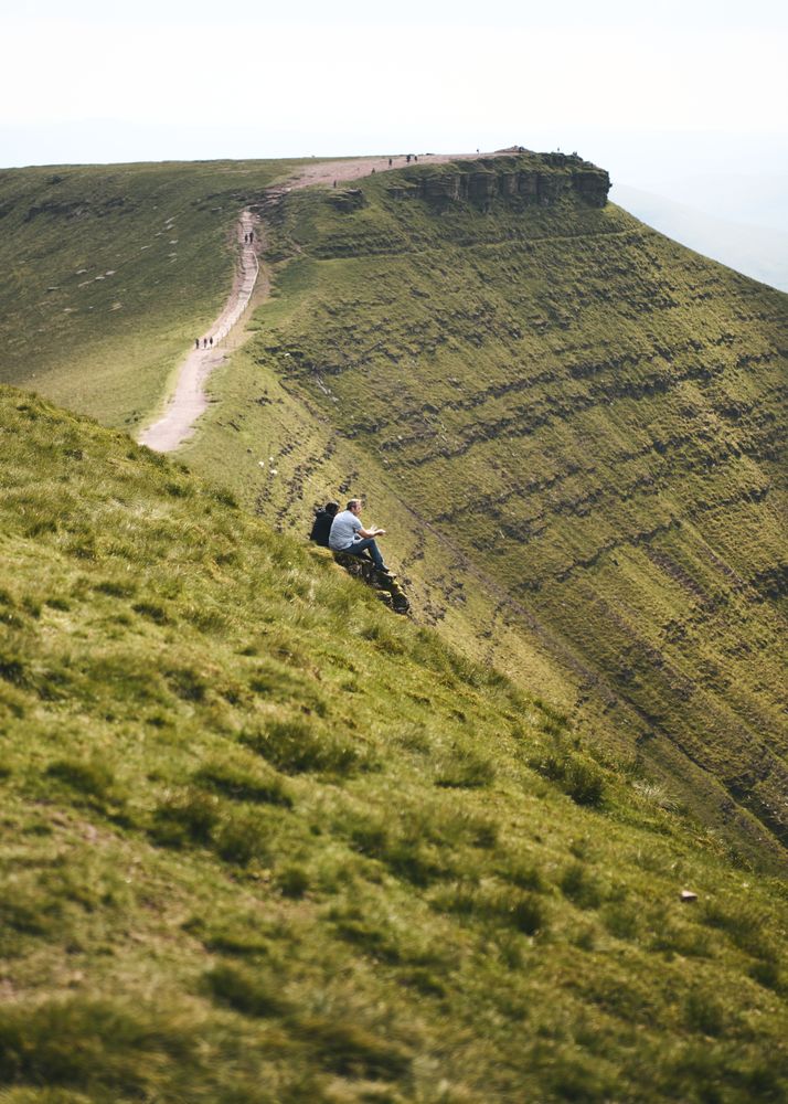 People sitting after hiking up the Brecon Beacons