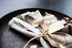 Table setting with decorative cotton and feathers with napkin on plate
