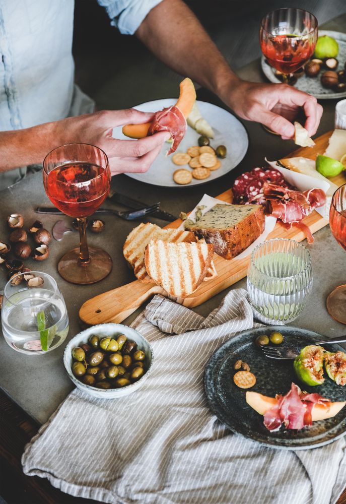 Charcuterie, with wine and snacks and man with prosciutto and melon