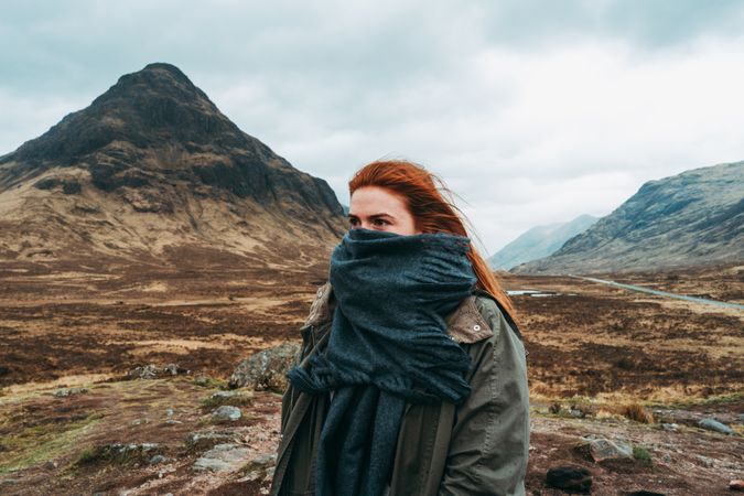 Redhead woman in scarf against mountains