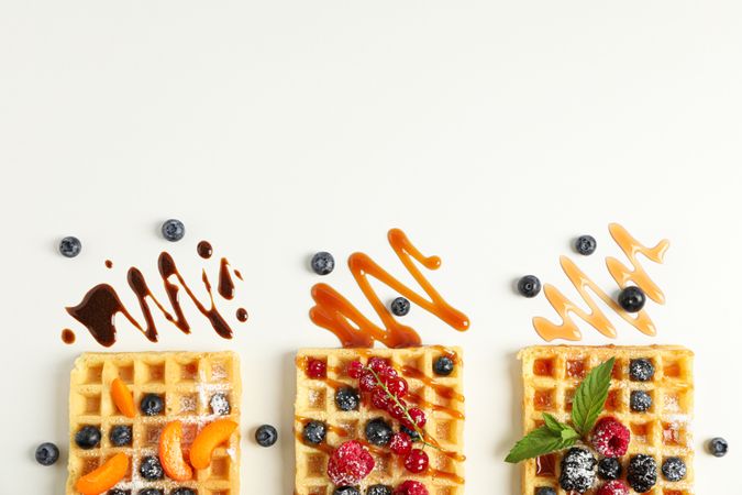 Flat lay composition with waffles and different toppings, top view