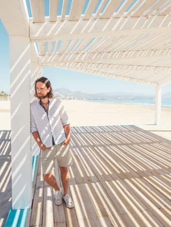 Relaxed man standing in gazebo on beach