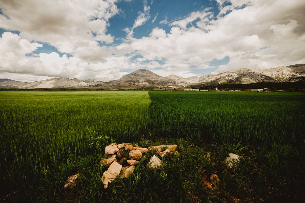 Big field and high hills in cloudy weather