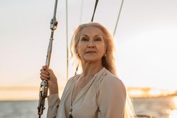 Portrait of elegant older woman on a sailboat at dusk