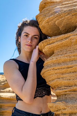 Young female leaning on sandstone rock