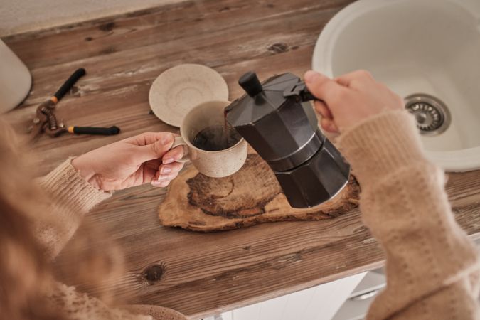 Unrecognizable woman making tasty coffee with moka pot