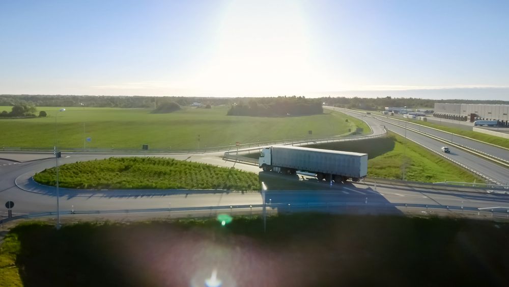 Aerial Top View of Truck with Cargo Semi Trailer Moving on the Road in the Direction of Loading Warehouse