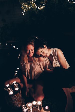 Couple with candles resting in night garden