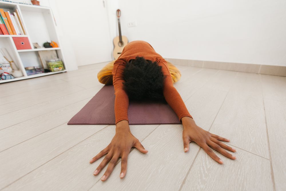 Anonymous sportive woman on the floor in yoga pose