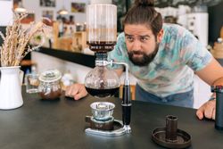 Barista skillfully brewing specialty coffee with Japanese siphon coffee maker