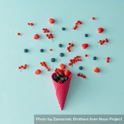 Red waffle cone with berries on blue background 4OWdL4