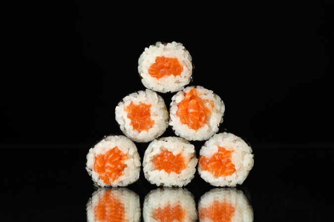 Delicious sushi rolls on dark mirror background. Japanese food