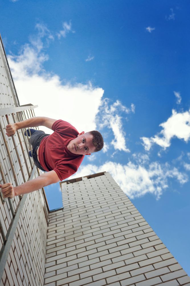 Looking up at man descending ladder face first