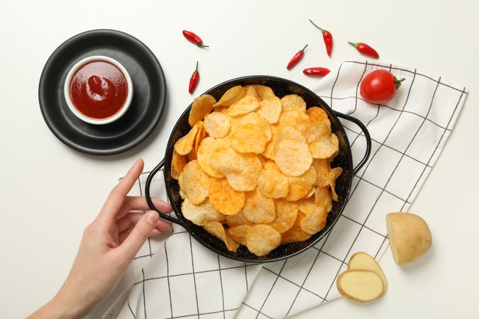 Potato chips in a bowl with chili pepper and sauce