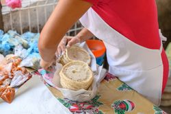 Faceless cook organizing delicious tortillas on table