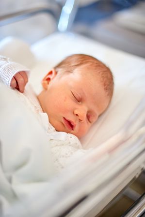 Newborn baby sleeping in its hospital crib